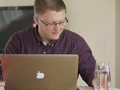 在线 student using a laptop in a business setting.